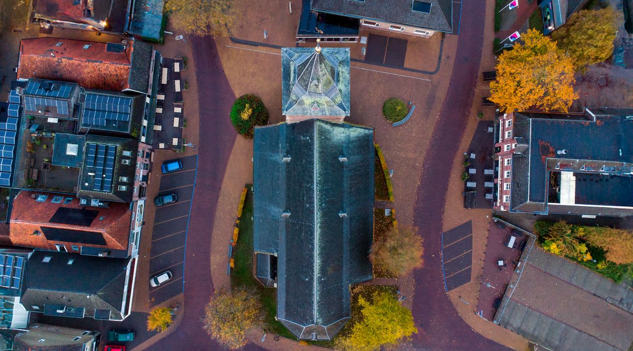 A captivating aerial view of a historic church surrounded by buildings in a quaint Dutch town.